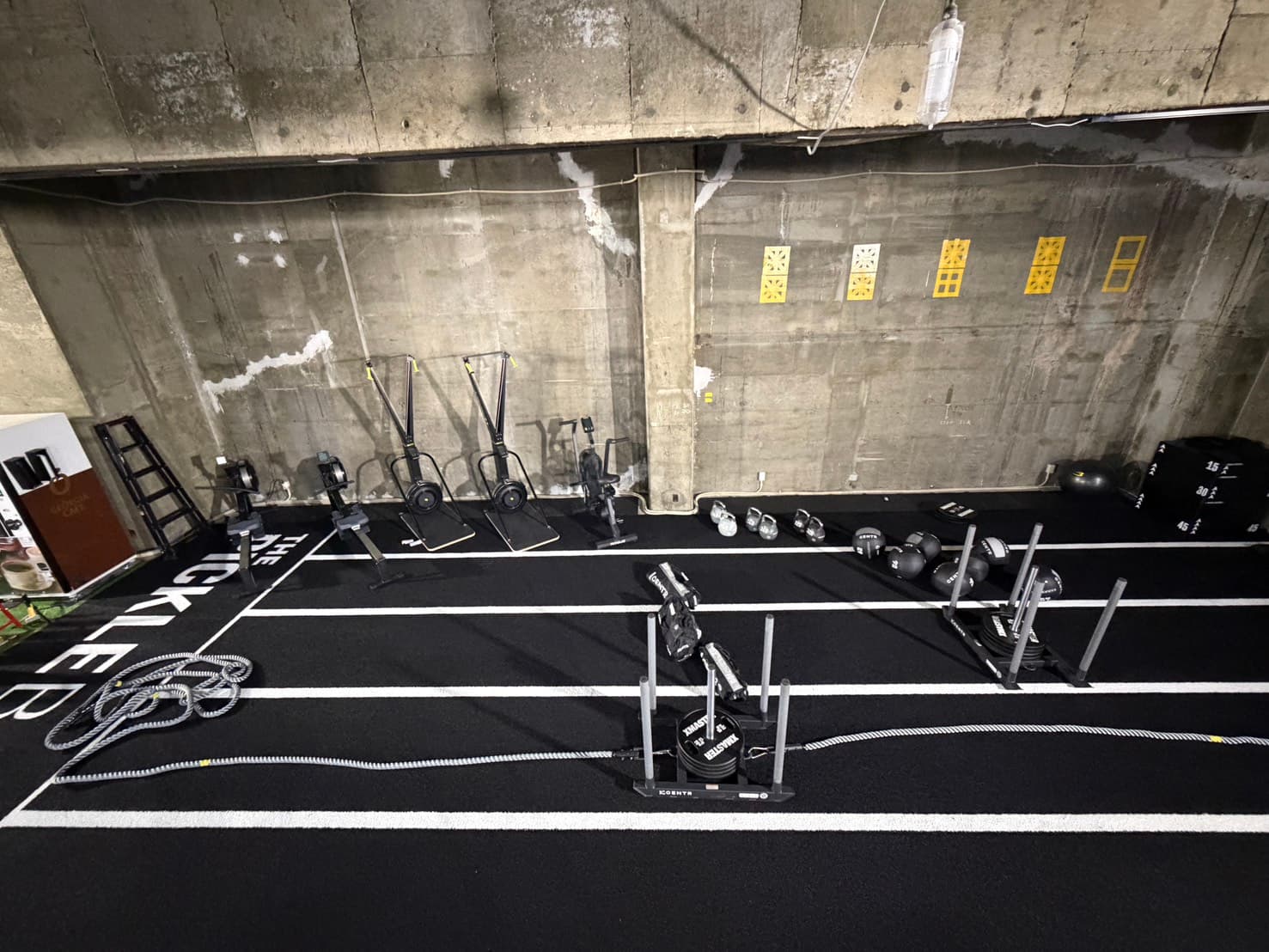 Full view of the HYROX training area with rowing machines and wall balls