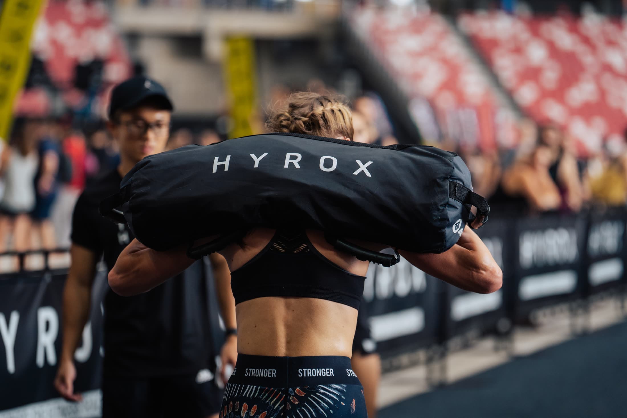 HYROXのサンドバッグを担ぐ女性アスリート
